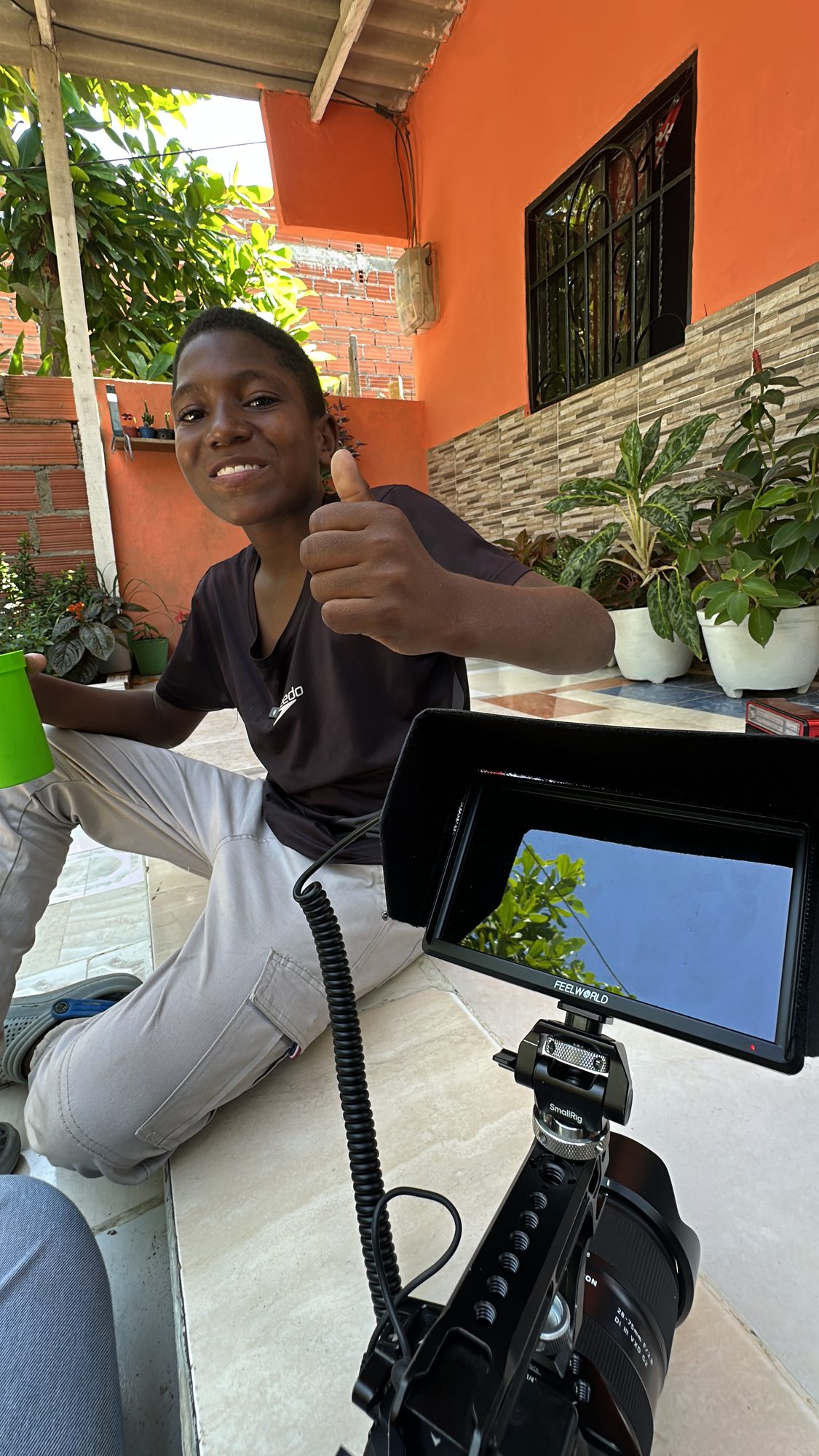 Niño haciendo pulgar arriba junto al monitor de la cámara durante una grabación