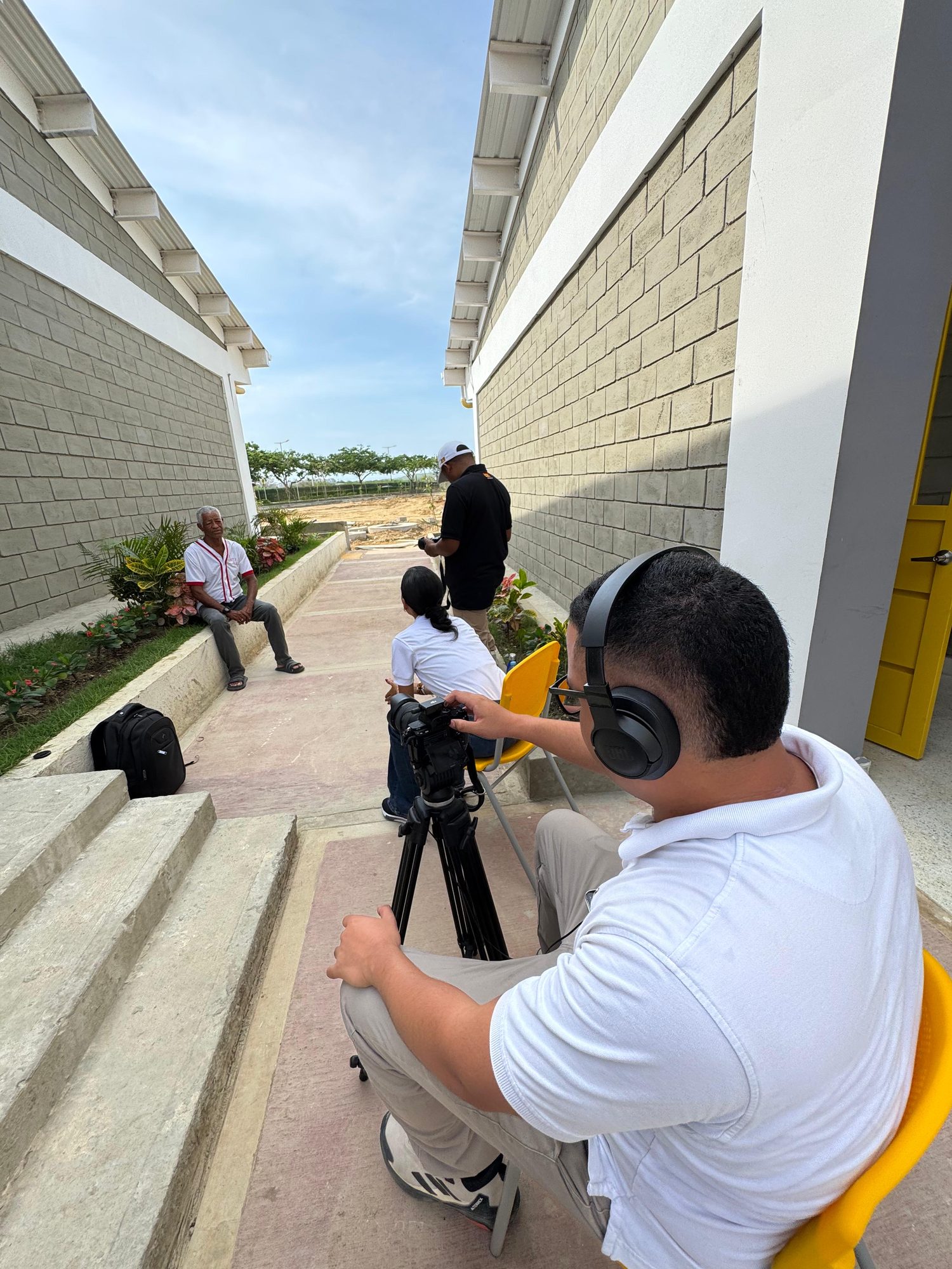 Camilo con audífonos grabando una entrevista con cámara en trípode