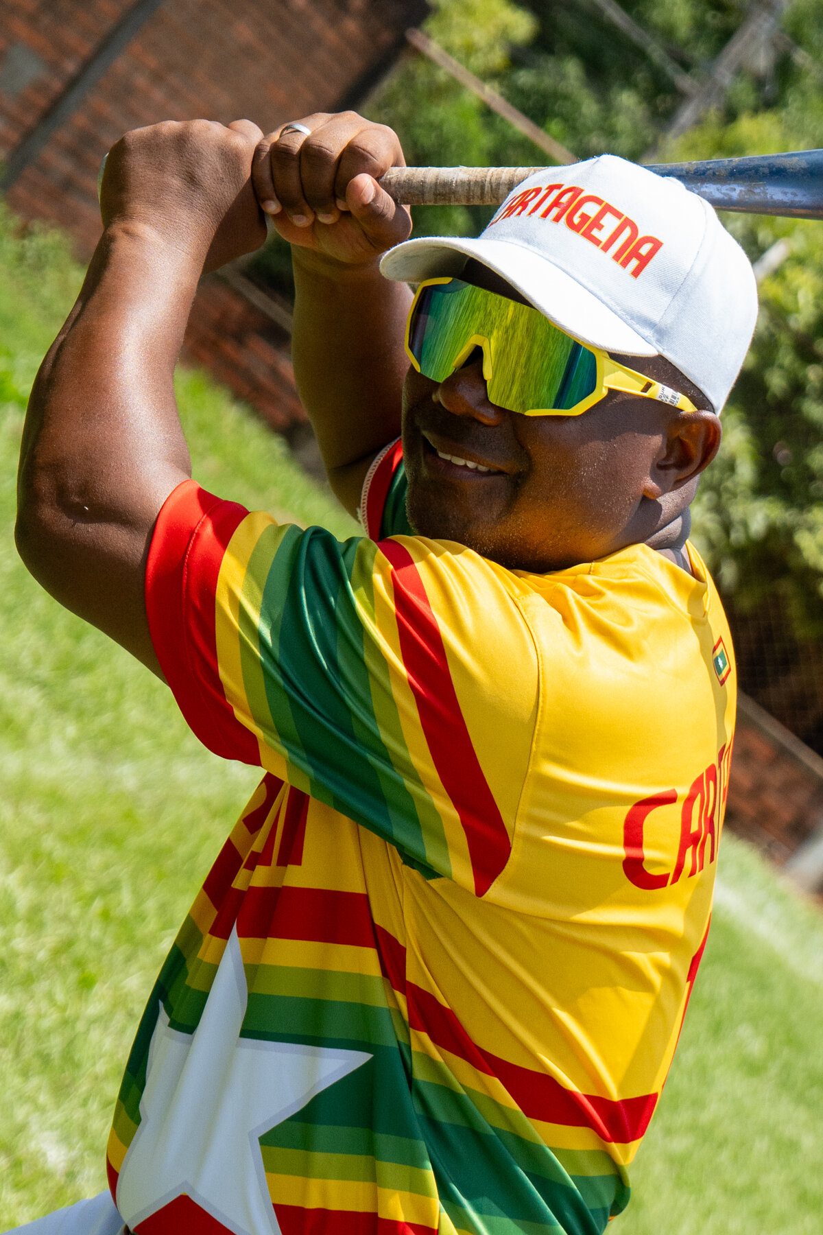 Jugador de béisbol conectando un batazo con gafas de sol