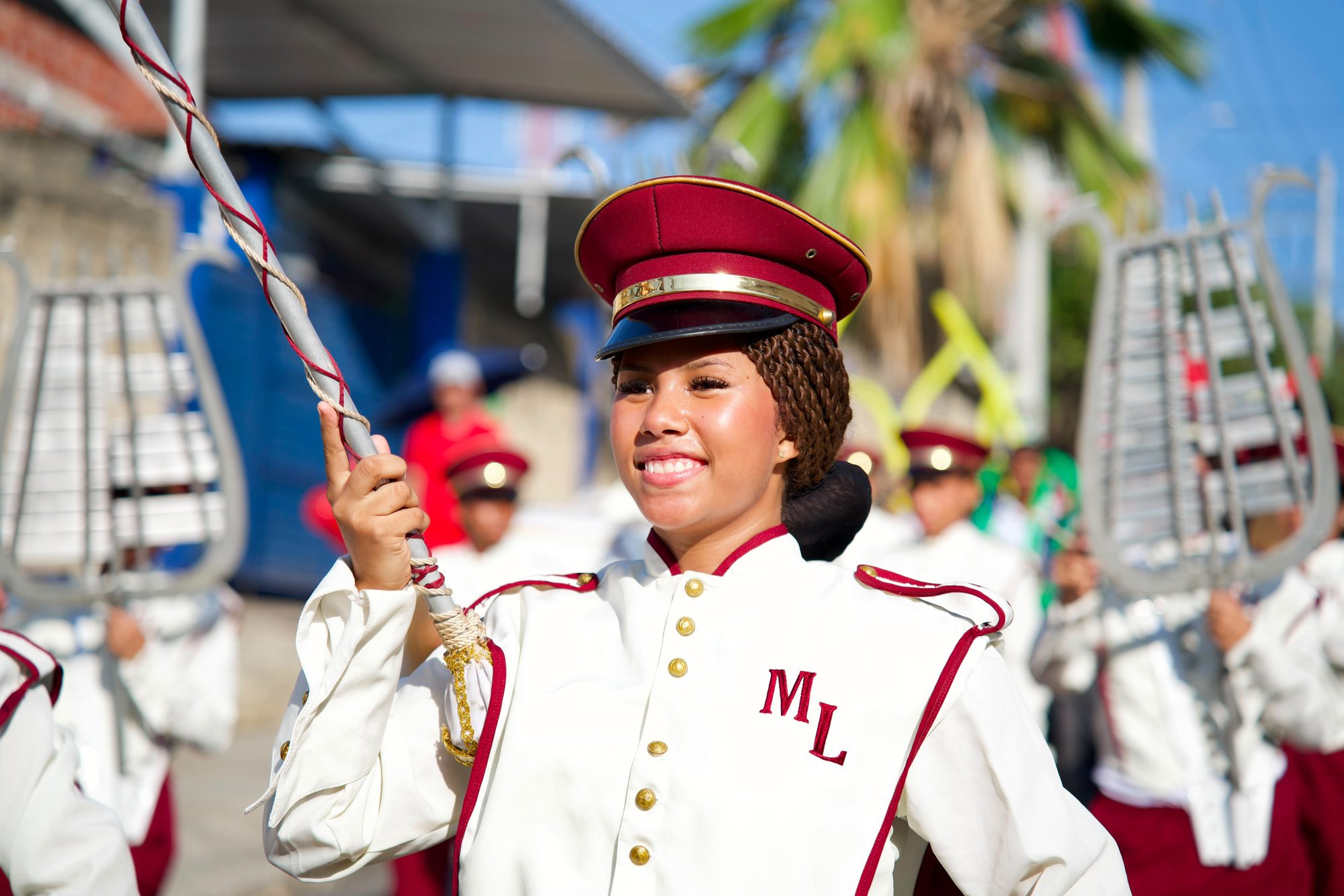 Retrato de una joven de banda marcial con gorra roja sonriendo