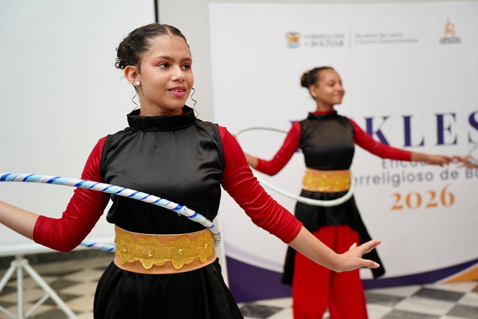 Niñas bailarinas girando aros durante un encuentro interreligioso