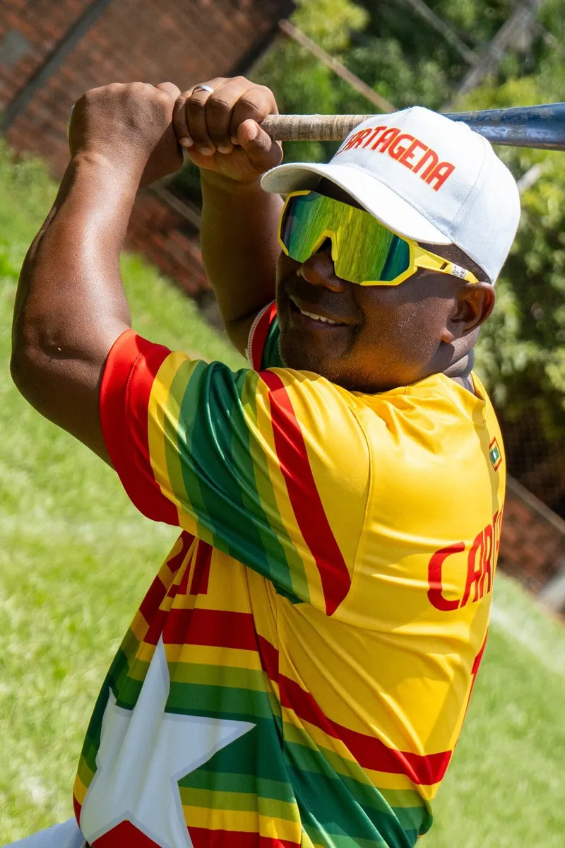 Jugador de béisbol conectando un batazo con gafas de sol